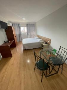 a hotel room with a bed and a table and chairs at Harbor Self Buriti Hotel in Campo Grande