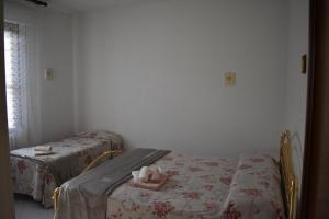 een kamer met 2 bedden, een tafel en een raam bij La Casa dei Nonni in Certaldo