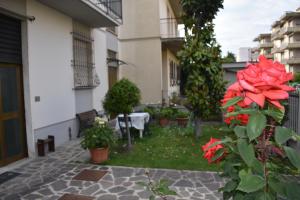 een binnenplaats van een gebouw met een tafel en rode bloemen bij La Casa dei Nonni in Certaldo