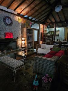 uma sala de estar com um sofá e um relógio na parede em Pousada Vinhas do Pinhal em Santo Antônio do Pinhal