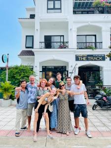 een groep mensen die poseren voor een foto voor een gebouw bij The Track Homestay in Cam Lâm
