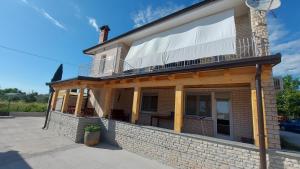a brick house with a balcony on top of it at Family apartment Cathy in Galižana