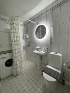 La salle de bains blanche est pourvue de toilettes et d'un lavabo. dans l'établissement VesiLahti RoofLevel Apartment, à Lahti