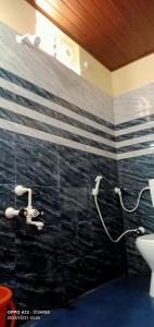 baño con pared de rayas en blanco y negro en Trip cabin en Gokarna