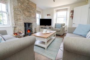 a living room with a stone wall and a fireplace at Rose Villa in Newlyn