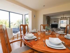 a dining room with a wooden table with wine glasses at Rose Villa in Newlyn