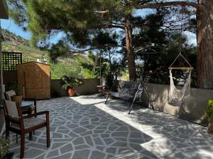 d'une terrasse avec une chaise et un hamac. dans l'établissement Natural House with Pool & private parking, à Héraklion