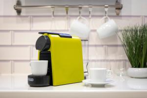 a yellow coffee maker sitting on a counter with two cups at Romantic-Fireplace-Centrum-Bathtub in Kőszeg