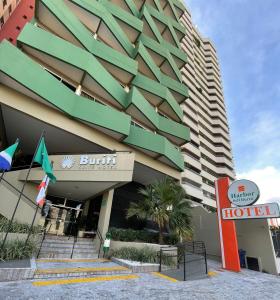 um edifício de hotel com uma placa de hotel em frente em Harbor Self Buriti Hotel em Campo Grande