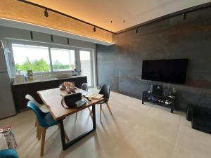 a living room with a table and a flat screen tv at Villa con piscina L’Approdo in Barletta