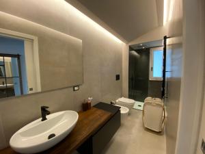 a white bathroom with a sink and a toilet at Villa con piscina L’Approdo in Barletta