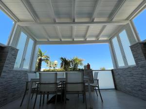 a conservatory with a table and chairs and a large window at Villa con piscina L’Approdo in Barletta