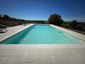 a swimming pool with blue water and benches in it at Maison Cabet in Castelnavet +24 photos