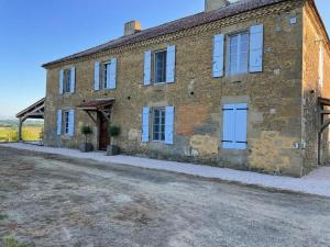 an old brick house with a dirt road in front of it at Maison Cabet in Castelnavet