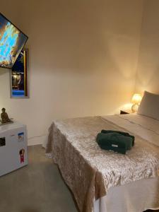 Un dormitorio con una cama con una bolsa verde. en Chalé Capão Vibes en Vale do Capao