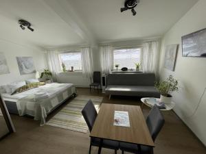 1 dormitorio con cama, mesa y sofá en VesiLahti RoofLevel Apartment, en Lahti