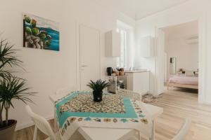 a white dining room with a table and chairs at Sofia's Central Apartment Palermo in Palermo