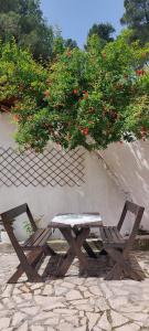 a picnic table and a bench under a tree at Niku HomeStay in Berat