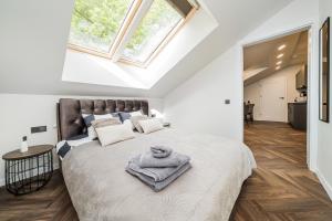 a bedroom with a large bed and two windows at Riverra House - Two-bedroom Apartment in Kaunas