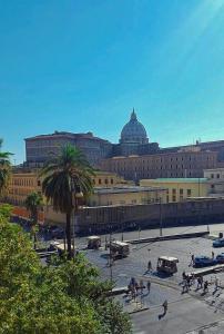 een groot gebouw met een palmboom ervoor bij St Peter Regal Apartment in Rome