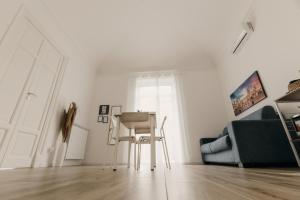 a white living room with a chair and a couch at Sofia's Central Apartment Palermo in Palermo