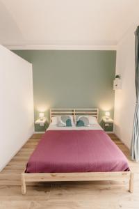 a bedroom with a large bed with a purple bedspread at Sofia's Central Apartment Palermo in Palermo