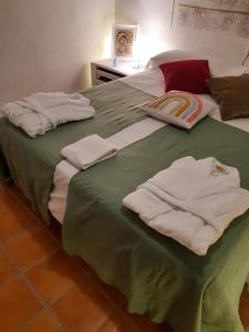 a bed with towels sitting on top of it at Musas Gastro Casa Rural in Valdealgorfa