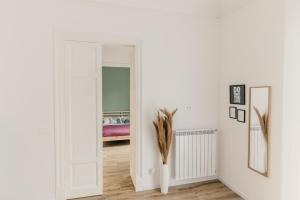 a room with a white door and a vase with feathers at Sofia's Central Apartment Palermo in Palermo