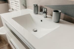 a bathroom with a white sink with two cups on it at Sofia's Central Apartment Palermo in Palermo