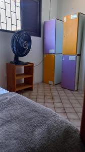 a room with a room with a fan on a dresser at Get Up Hostel in Natal