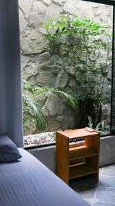 a bedroom with a table next to a stone wall at Get Up Hostel in Natal