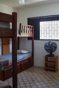a bedroom with two bunk beds and a fan at Get Up Hostel in Natal
