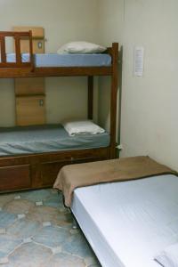 a bedroom with two bunk beds and a tiled floor at Get Up Hostel in Natal