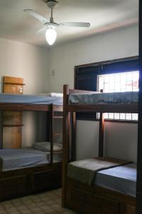 a room with three bunk beds and a ceiling fan at Get Up Hostel in Natal