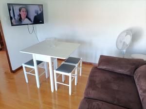 uma sala de estar com uma mesa branca e um sofá em Apartamento cerca de la playa em Santander