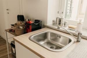 a kitchen counter with a stainless steel sink at Sofia's Central Apartment Palermo in Palermo