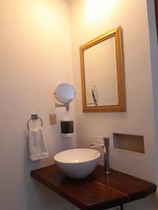 a bathroom with a bowl sink and a mirror at Xtabentun Hostal in Cancún