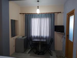 a table and chairs in a room with a window at Vila Green Relax in Vlorë