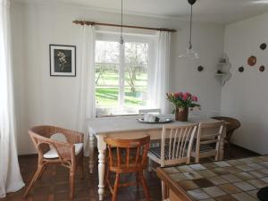 a kitchen with a table and chairs and a window at Reetdachhaus Eiderblick in Breiholz