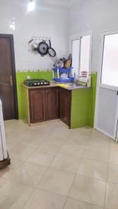 a kitchen with green walls and a counter top at One bedroom apartement at Martil 300 m away from the beach with city view and wifi in Martil