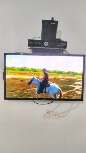 a television with a picture of a person riding a horse at One bedroom apartement at Martil 300 m away from the beach with city view and wifi in Martil