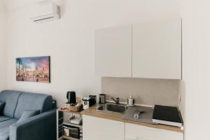 a kitchen with a couch and a sink in a room at Sofia's Central Apartment Palermo in Palermo