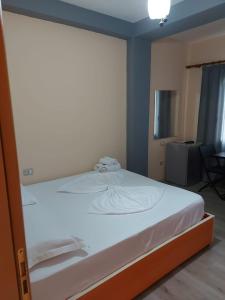 a white bed in a room with a window at Vila Green Relax in Vlorë