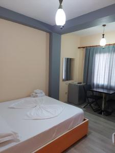 a bedroom with a white bed and a table at Vila Green Relax in Vlorë