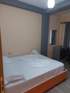 a bedroom with a white bed with a blue wall at Vila Green Relax in Vlorë