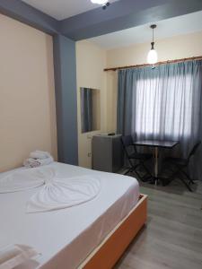 a bedroom with a bed and a table and a desk at Vila Green Relax in Vlorë
