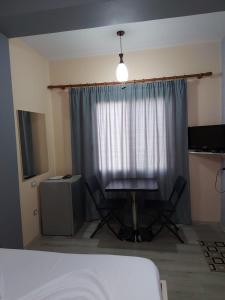 a bedroom with a table and two chairs in front of a window at Vila Green Relax in Vlorë