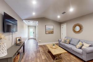 a living room with a couch and a table at Beach Cottage South in Dauphin Island