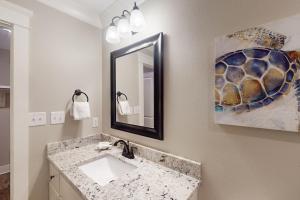 a bathroom with a sink and a mirror at Beach Cottage South in Dauphin Island +12 photos