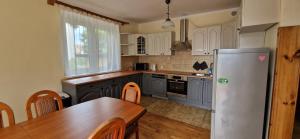 a kitchen with a wooden table and a refrigerator at Hostel Milicka in Wrocław